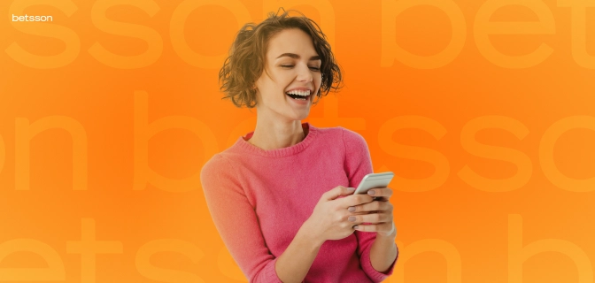 Imagem mostra mulher sorrindo ao utilizar um smartphone