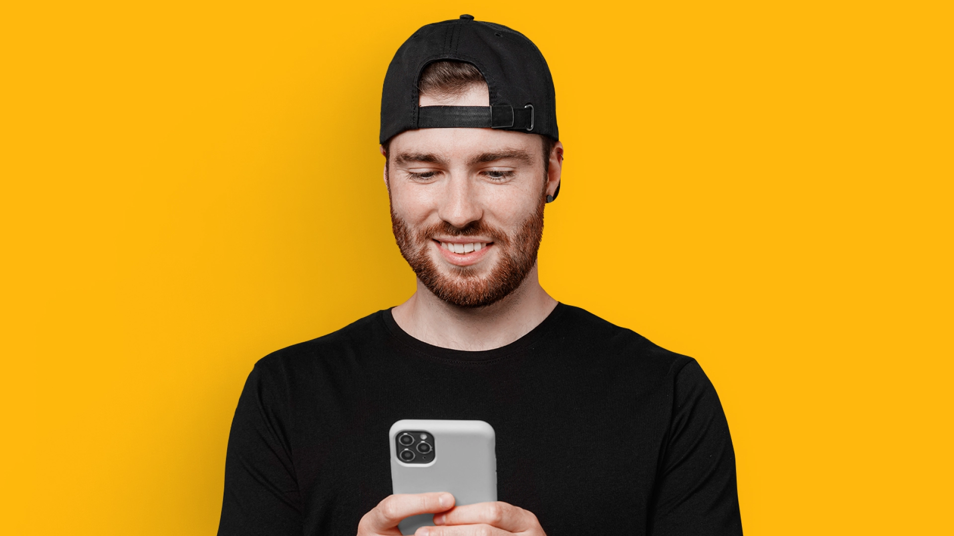 imagem mostra homem sorrindo ao utilizar um celular