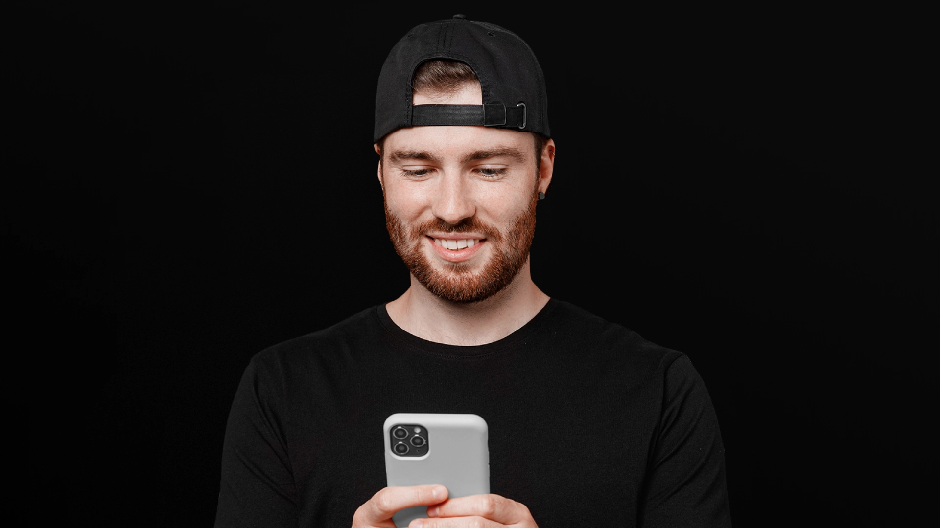 Imagem mostra homem sorrindo ao utilizar um celular