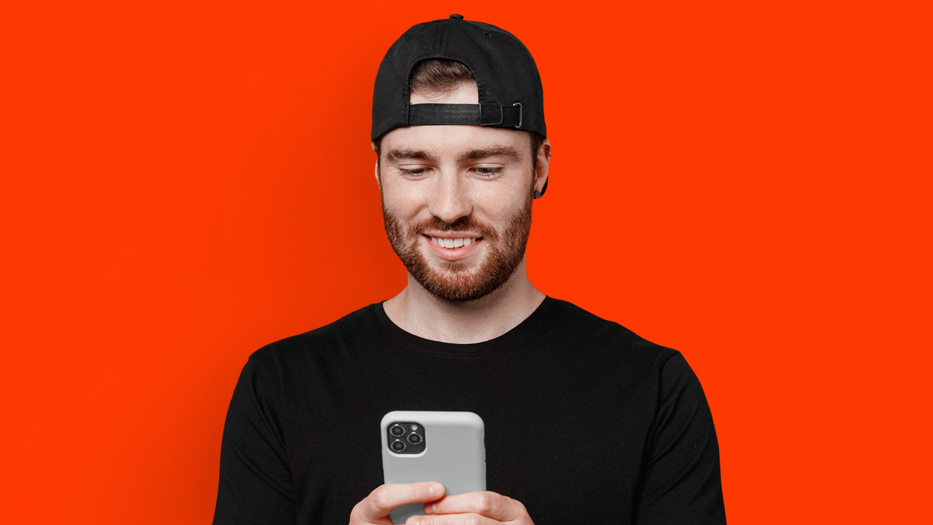 imagem mostra homem sorrindo ao utilizar um celular